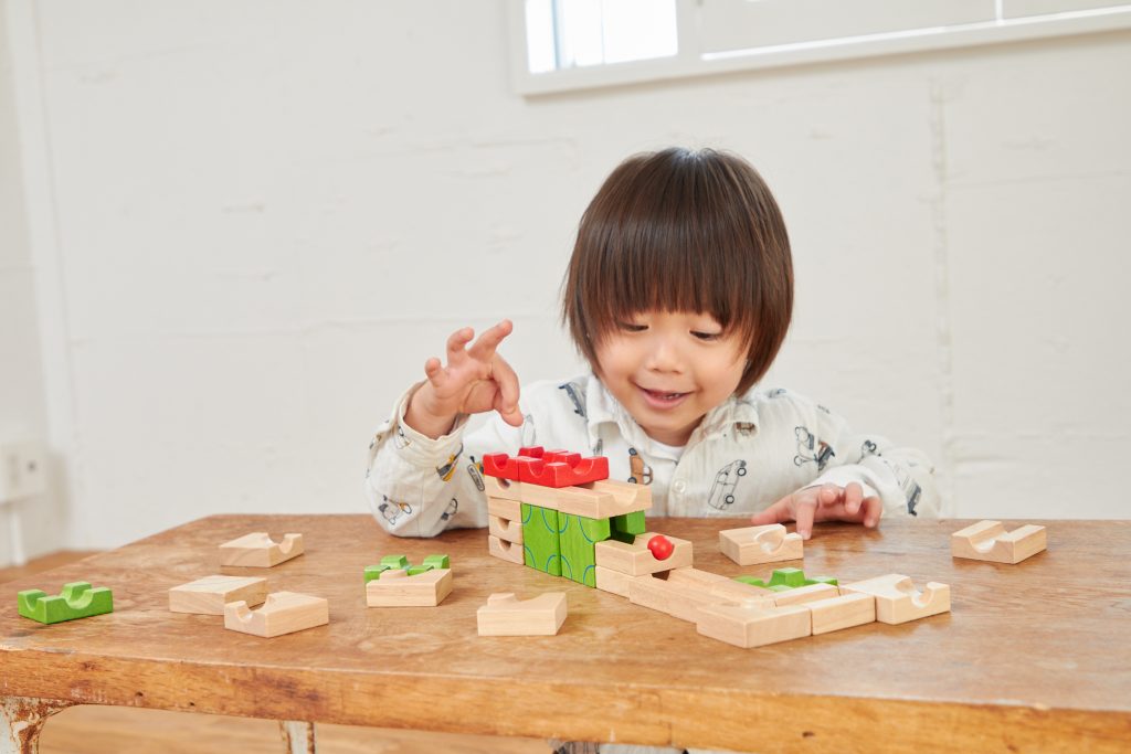 木のおもちゃで遊ぶ男の子