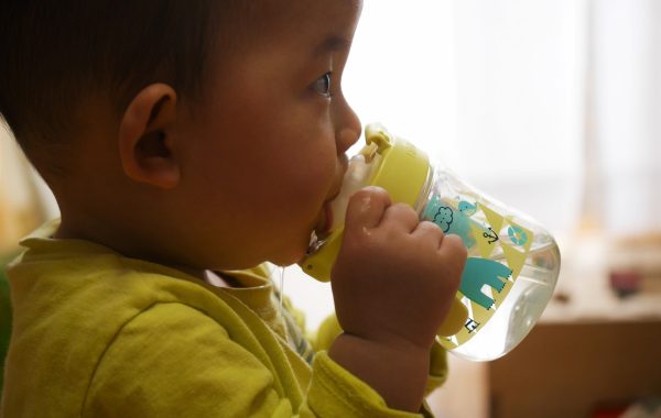 マグで飲む赤ちゃん